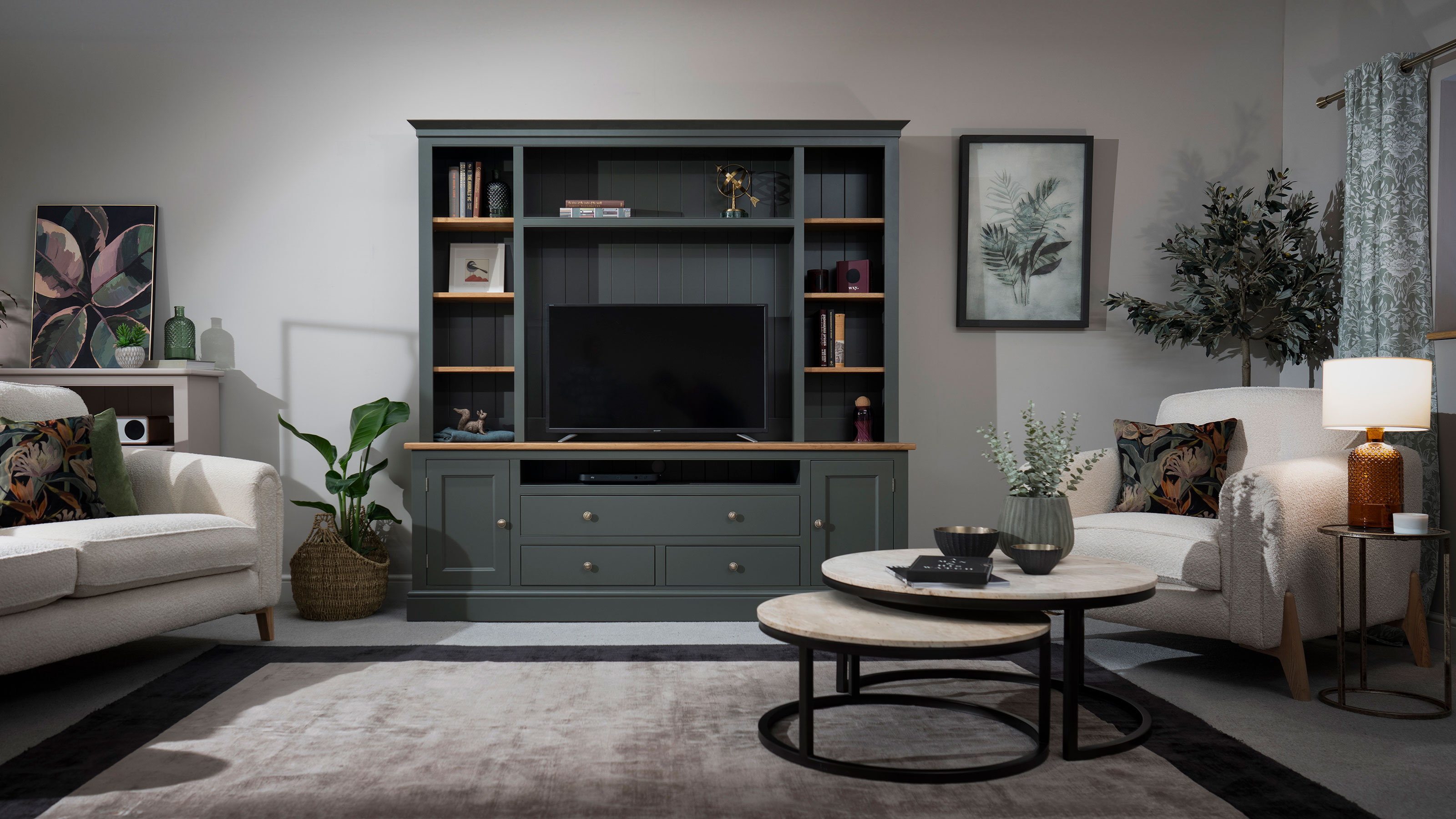 living room with green wooden media unit and round nesting tables