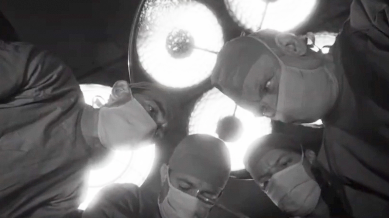 Four doctors with masks on looking down in Dr. Kildare