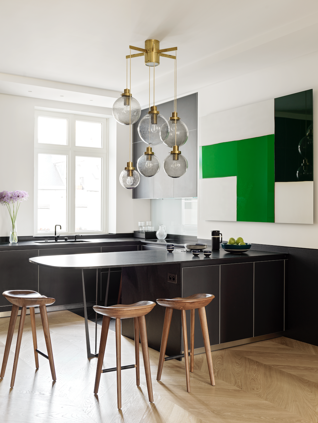 A kitchen with a long, black breakfast bar extending from the kitchen countertop
