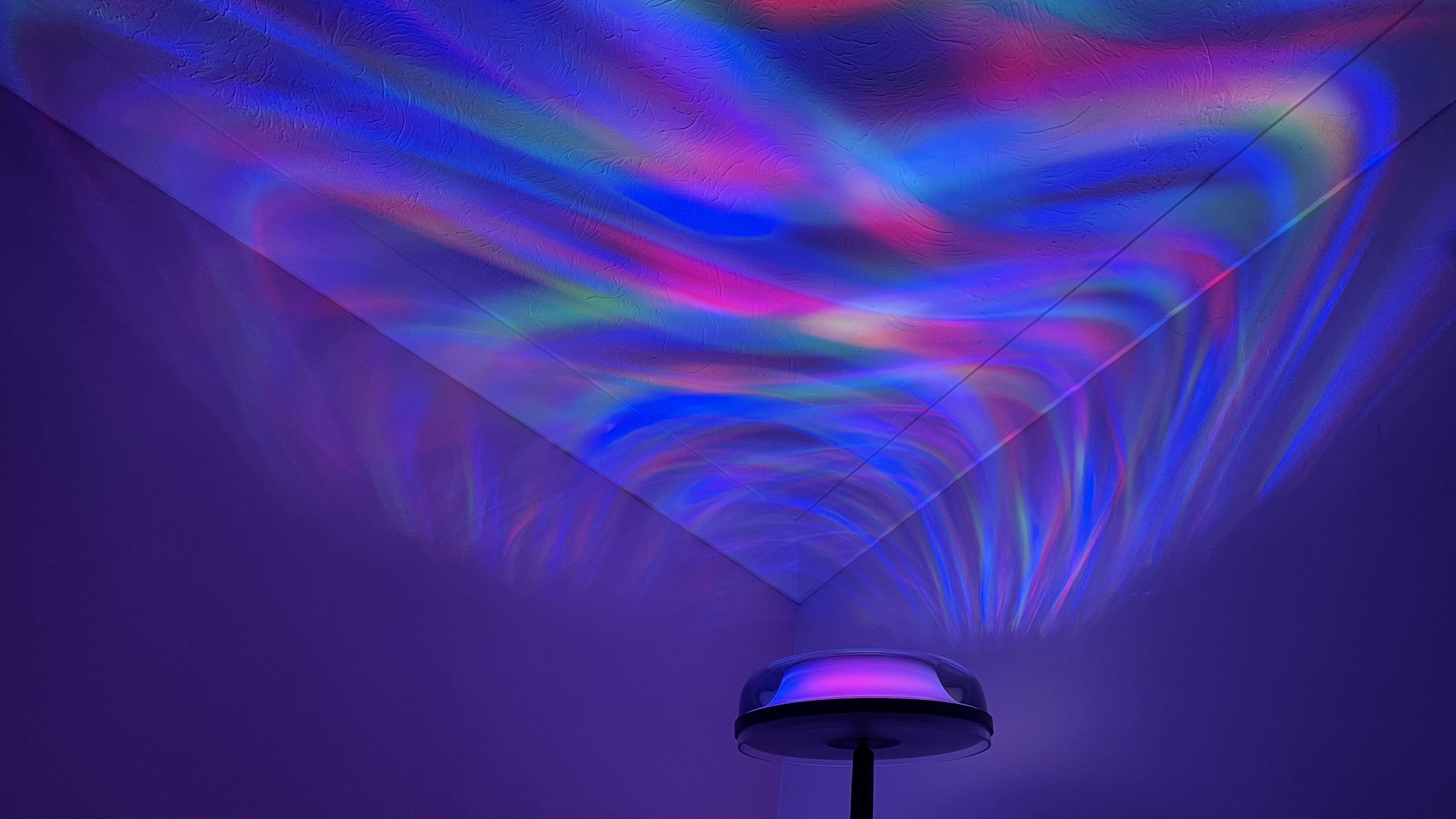 The Govee Uplighter Floor Lamp is in a corner, projecting an aurora borealis effect onto the ceiling.