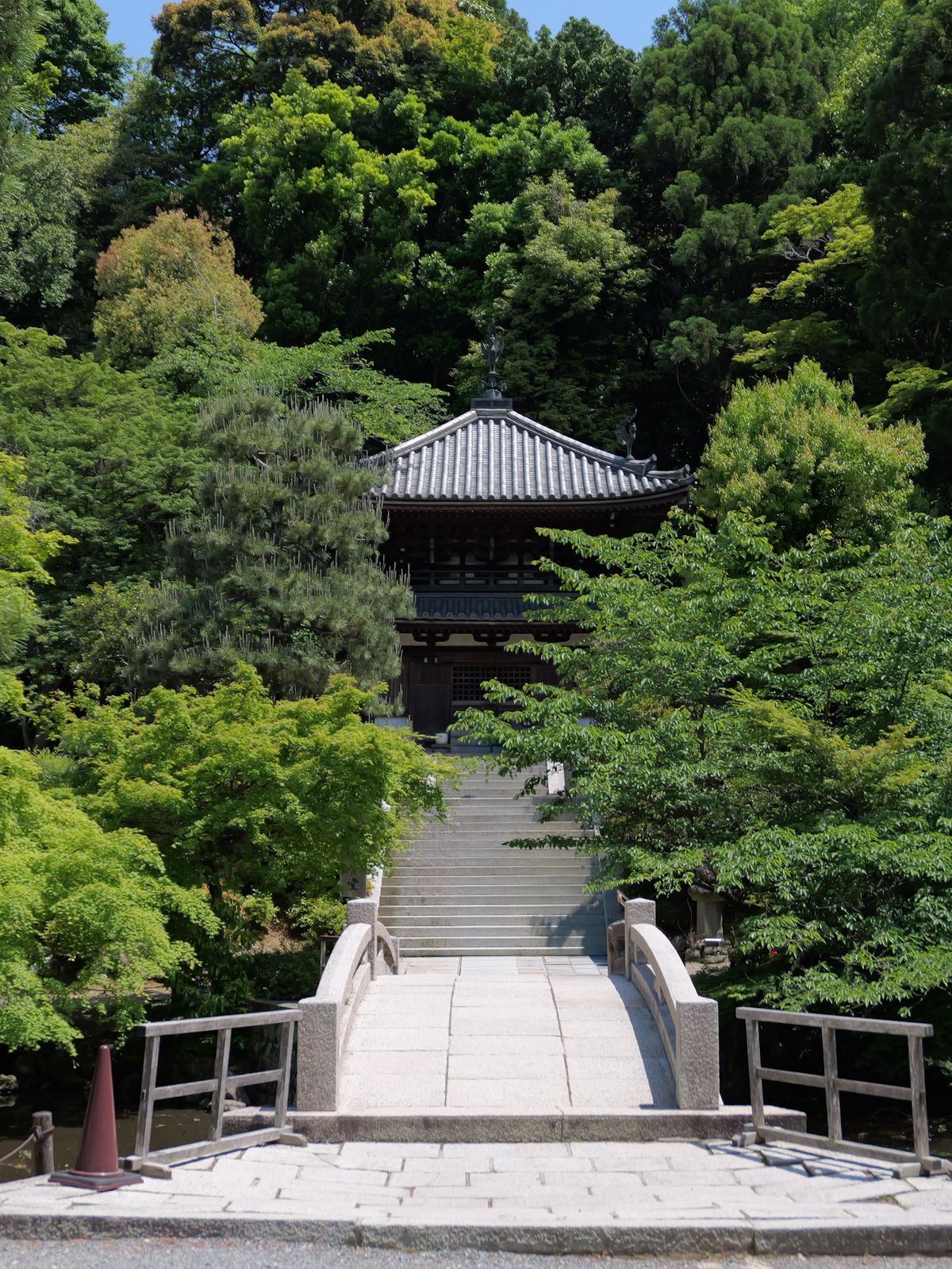 Small temple building surrounded by dense green trees.