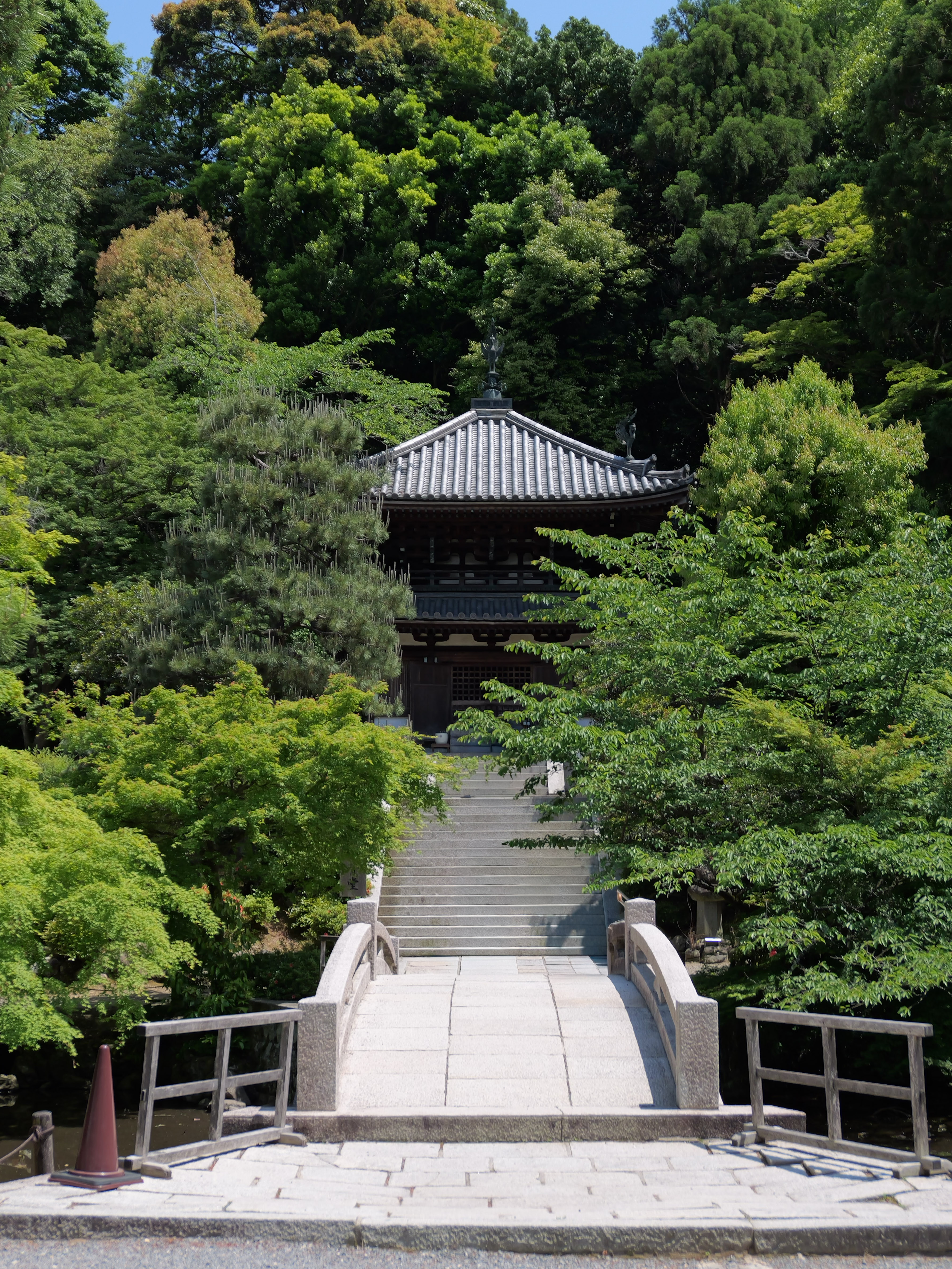 Small temple building surrounded by dense green trees.