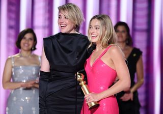 Greta Gerwig and Margot Robbie accept the award for Cinematic and Box Office Achievement for "Barbie" at the 81st Golden Globe Awards