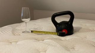 A wine glass, weight and tape measure on the Nolah Evolution 15" mattress