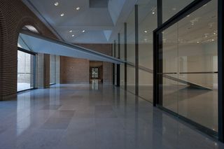 The entry at the Rice Gallery. A white asymmetrical structure is going through the glass and connects with the top of an arch.