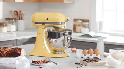 Yellow KitchenAid mixer in a kitchen with desserts