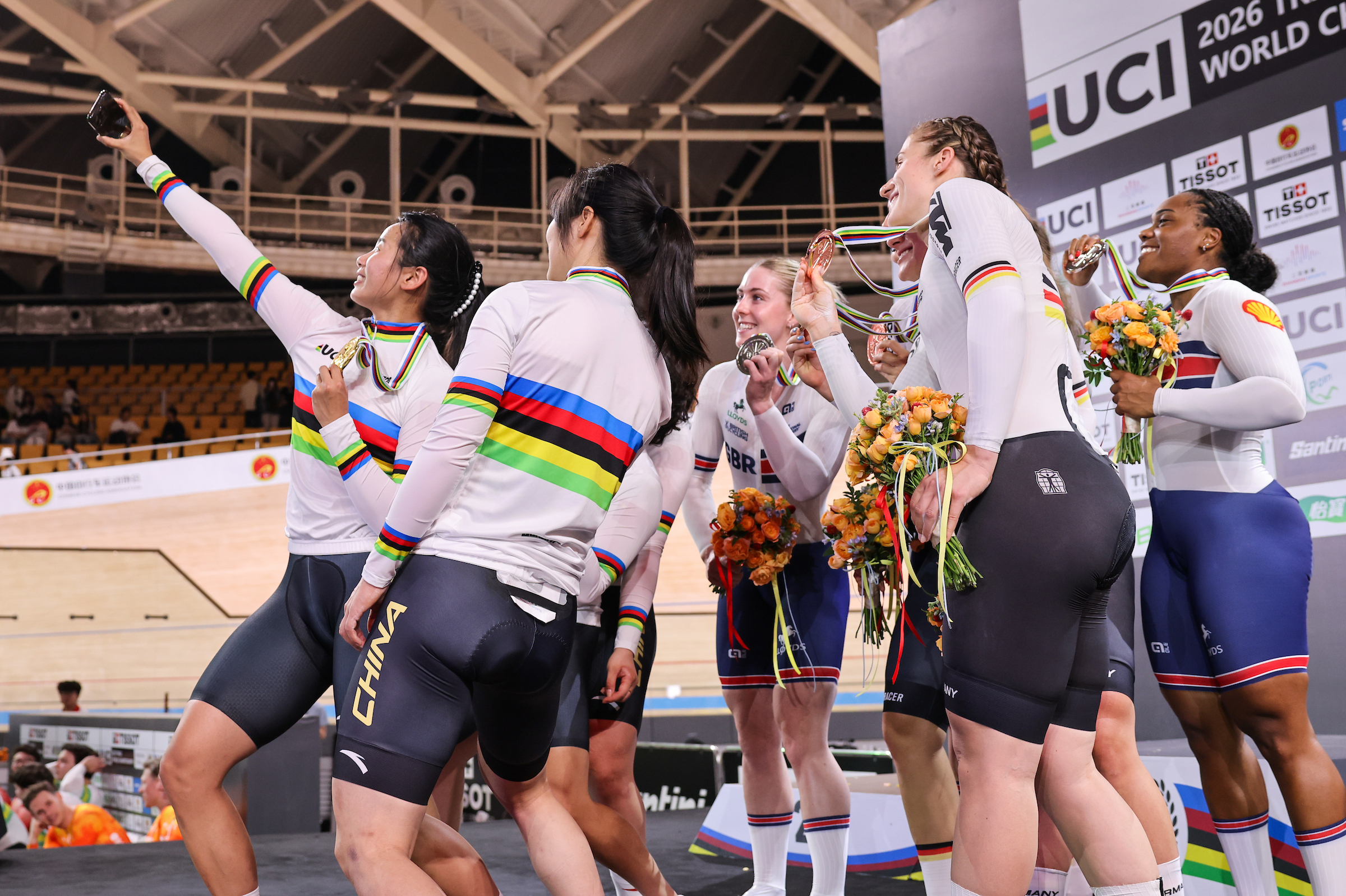 China, Germany, and Great Britain celebrate their women's team sprint medals on the podium with a group selfie