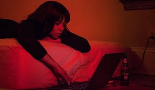 Acrimony Taraji P. Henson browsing on her computer bathed in red light
