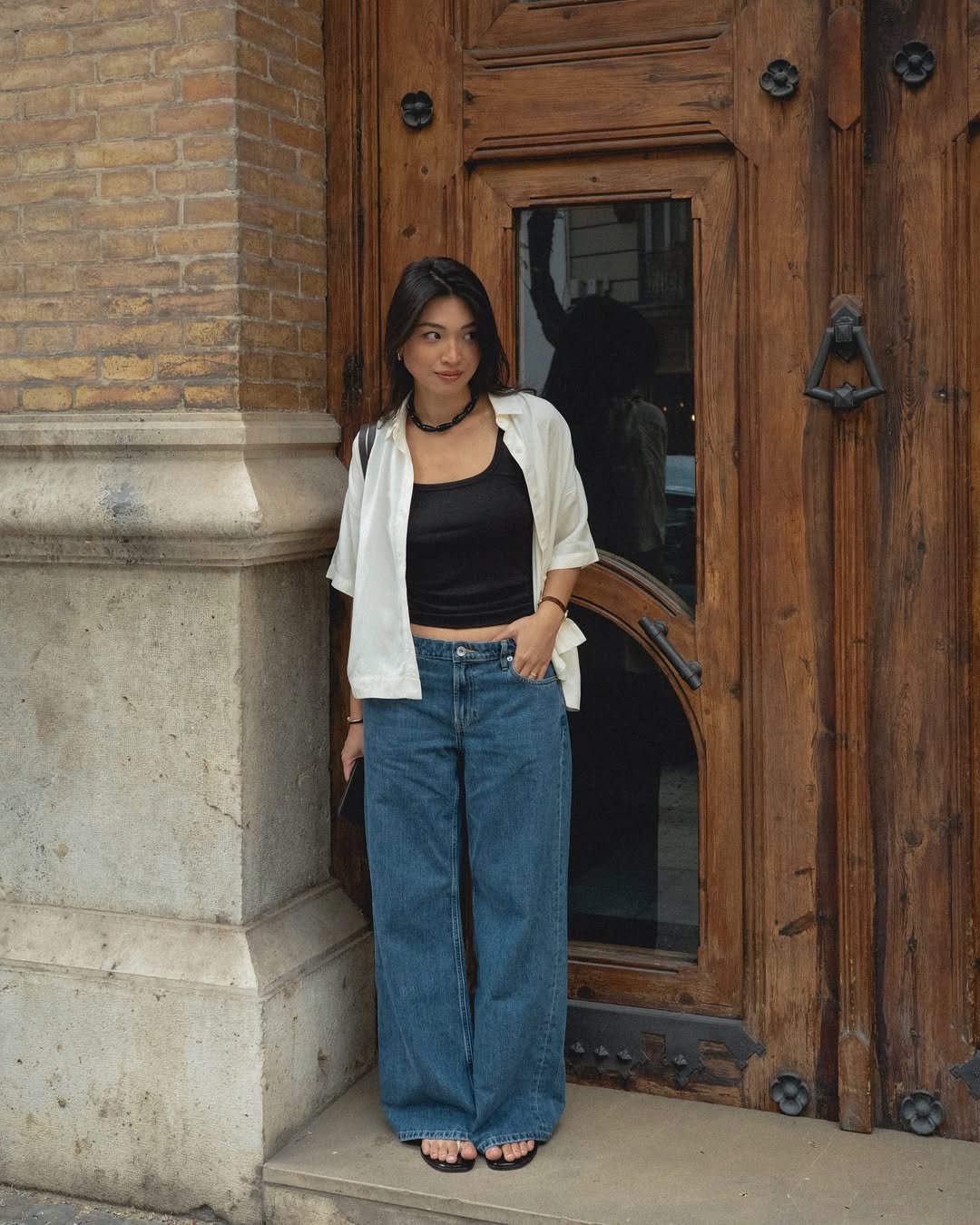 @michellelin.lin wears a black tank, white shirt, jeans and sandals