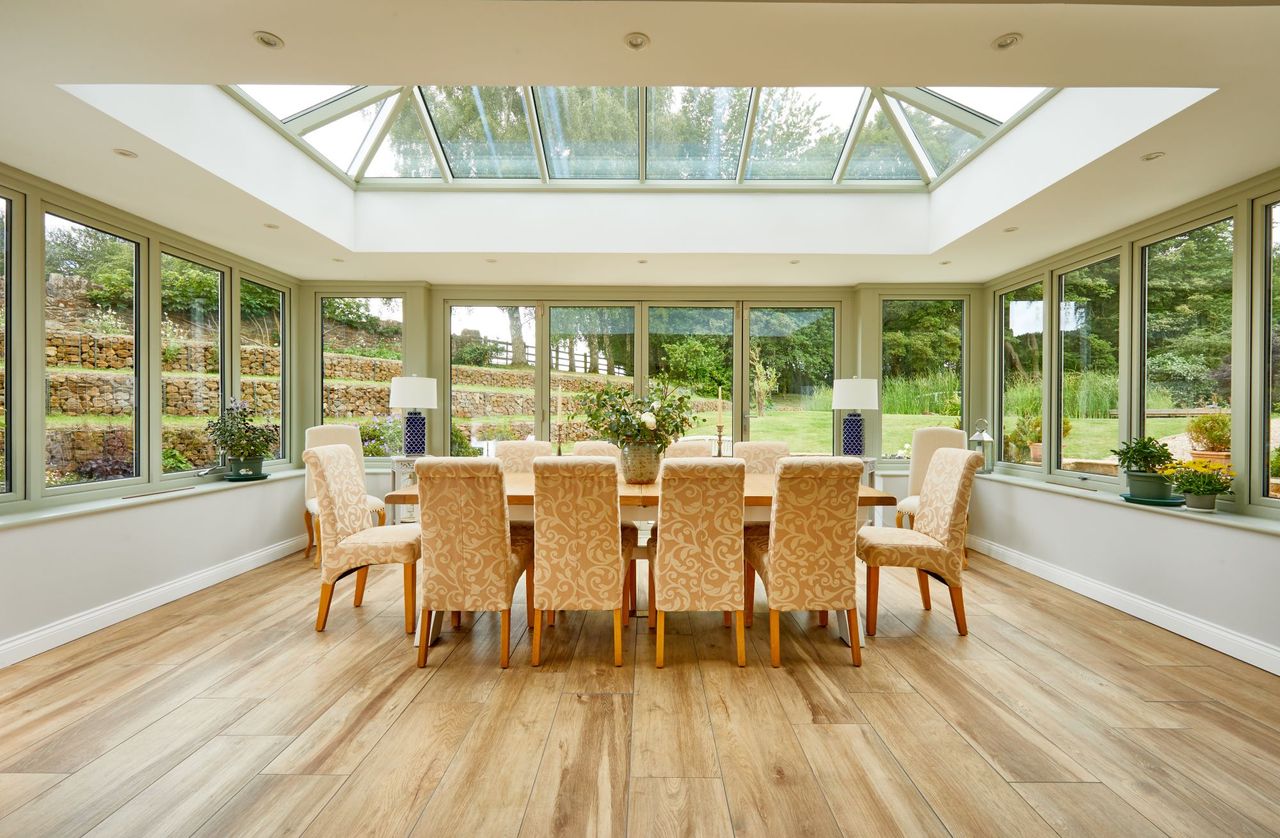 The orangery leads out to the outside terrace and is filled with a table and dining chair