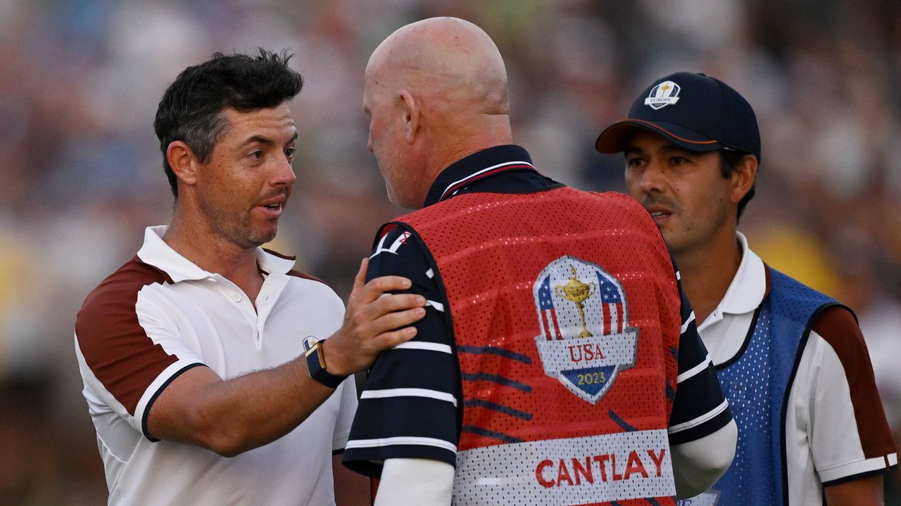 Rory McIlroy speaks to Patrick Cantlay&#039;s caddie Joe LaCava after their match at the Ryder Cup.