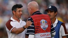 Rory McIlroy speaks to Patrick Cantlay's caddie Joe LaCava after their match at the Ryder Cup.