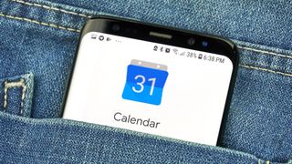 En telefon med appen Google Kalender i en bukselomme af et par jeans 