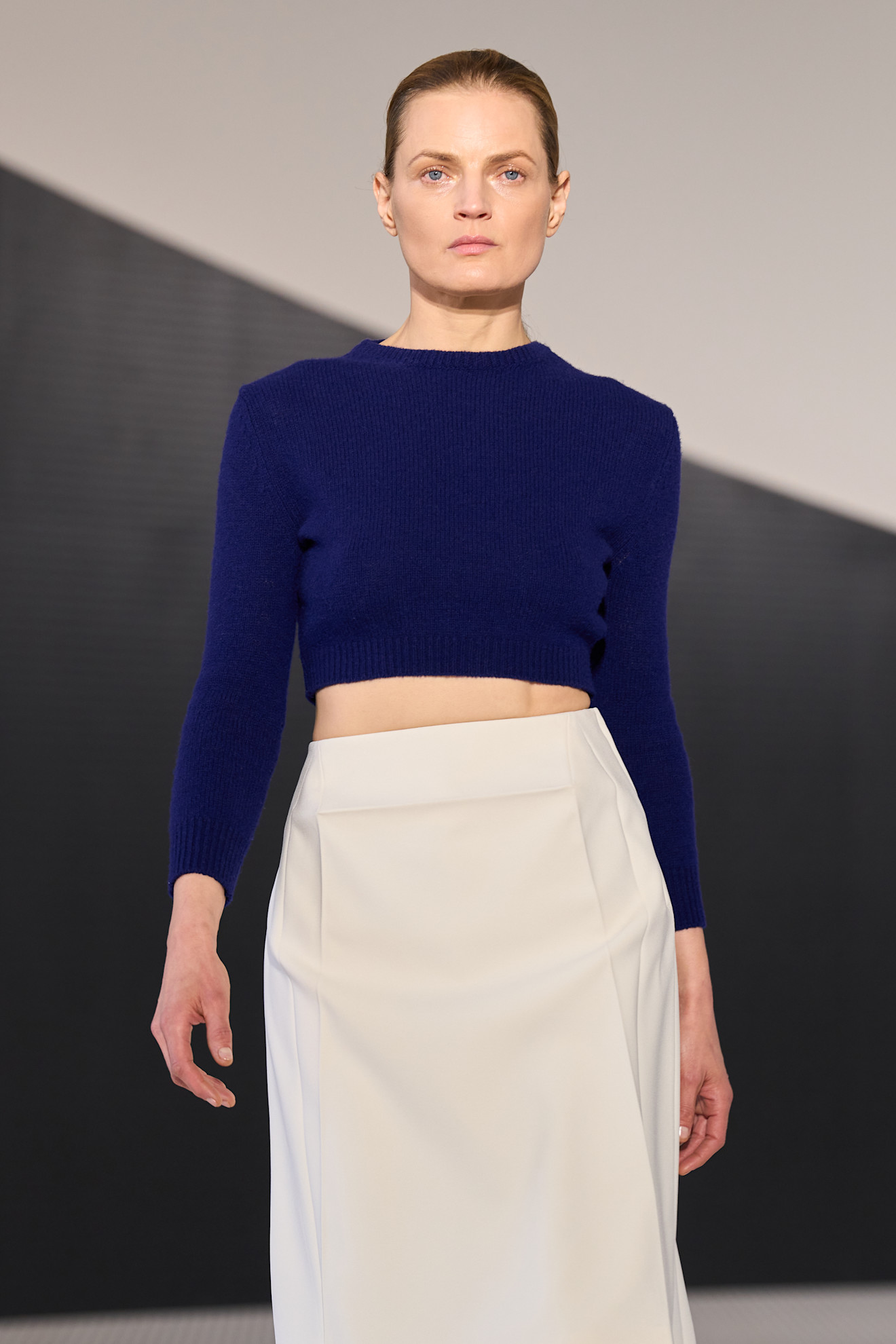 model wearing a blue cropped sweater and white midi skirt on the Jil Sander Spring 2026 runway