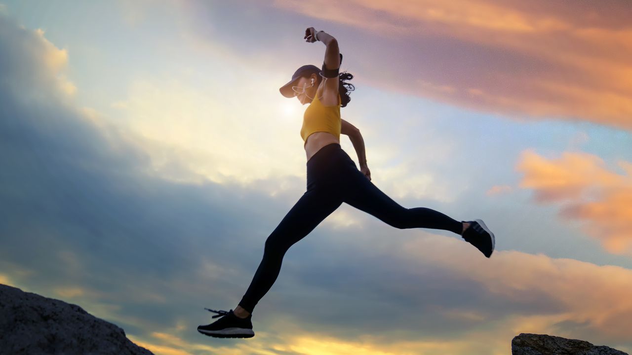 Woman jumping over rocks