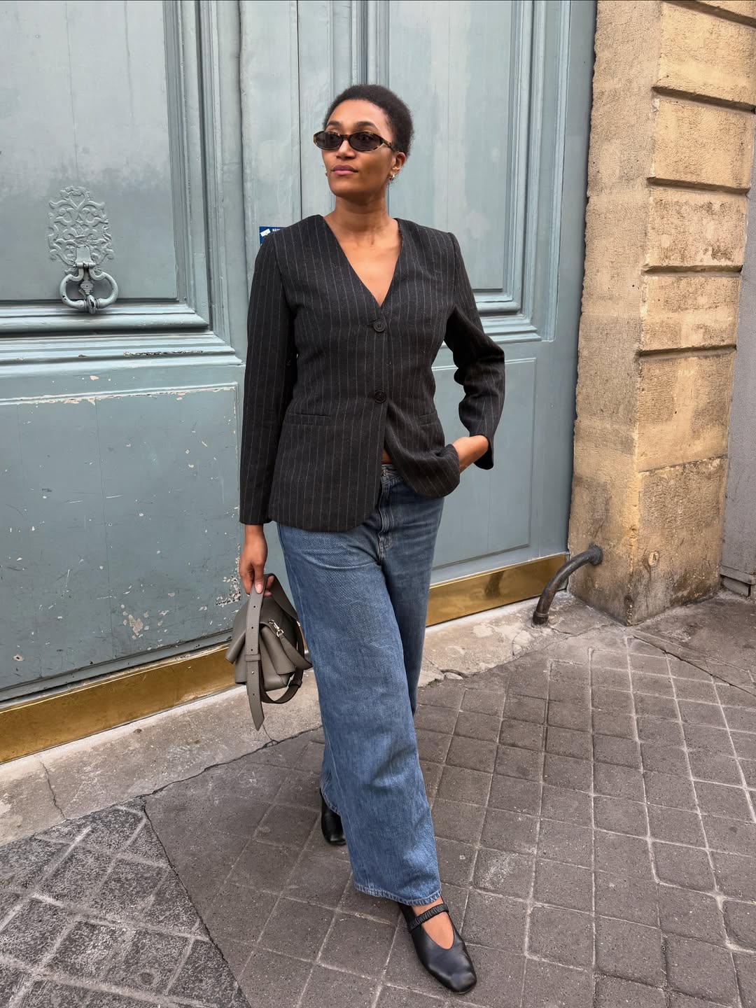 Influencer Lena Farl wearing a pinstripe blazer, wide-leg jeans and ballet flats.