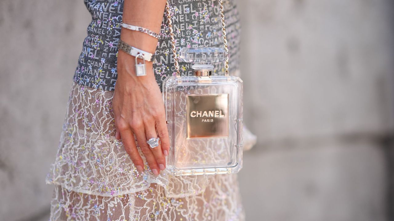 Woman wearing classic perfume bag Chanel No5 bottle handbag