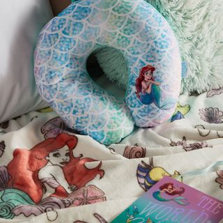 bedroom with bed and mermaid printed travel pillow