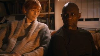 Tilda Swinton and Idris Elba sit next to each other in a bedroom in Three Thousand Years of Longing