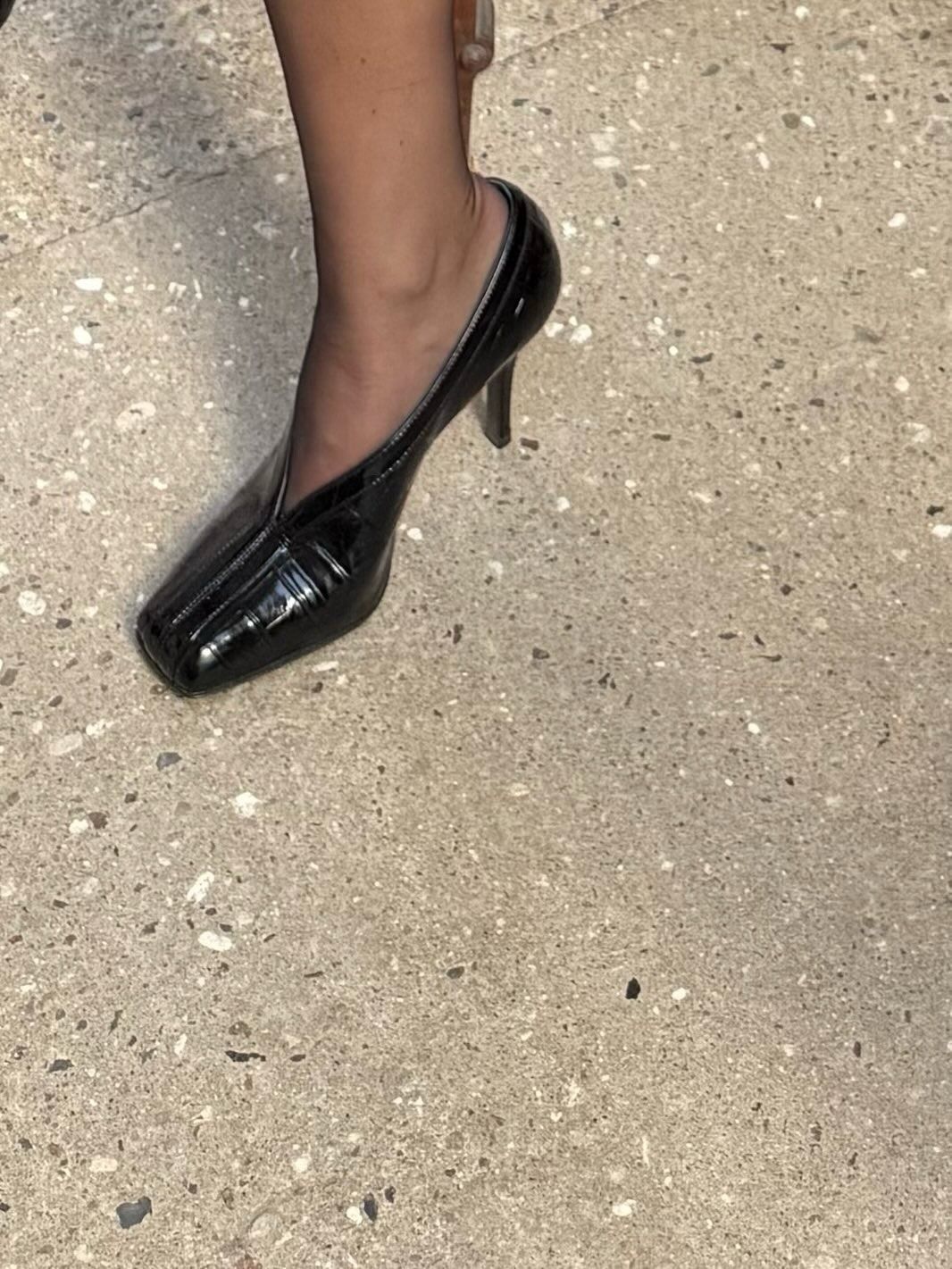 A woman wearing black leather eel shoes, a big fall 2026 micro-trend.