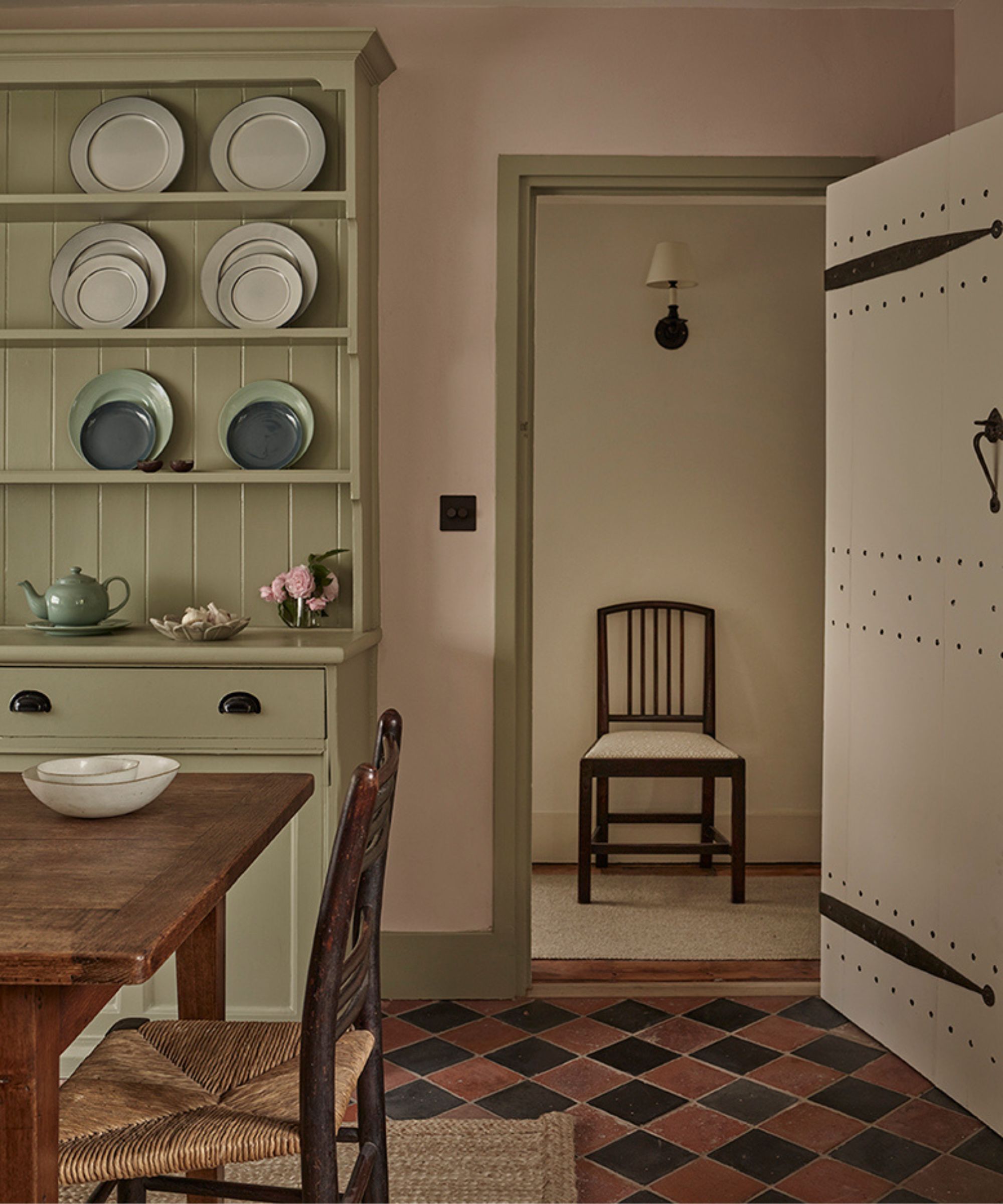 a breakfast room in london with a painted dresser and red and black quarry floor tiles