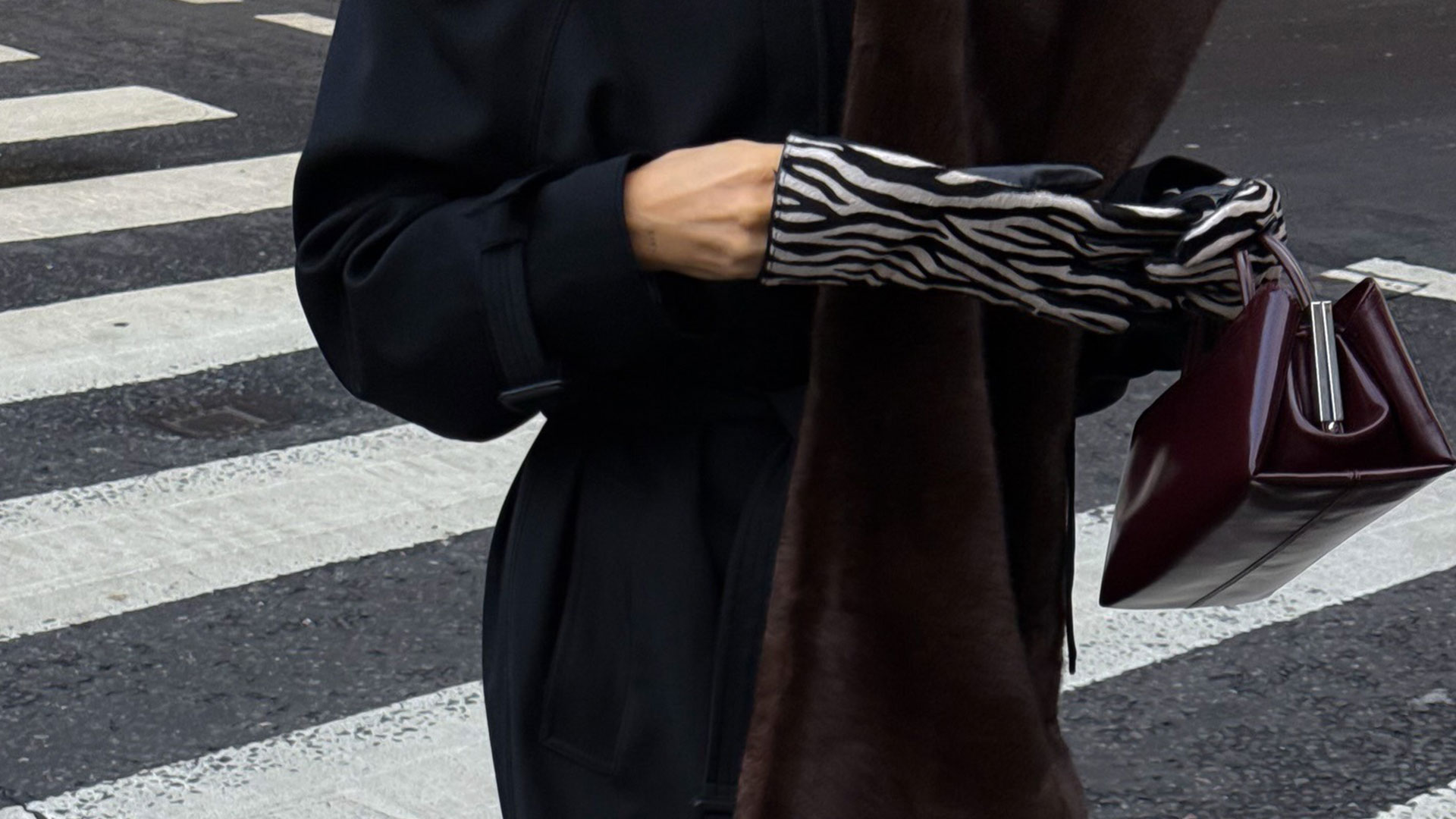 @hannahlewisstylist closeup shot of zebra print gloves, fur scarf, and burgundy bag