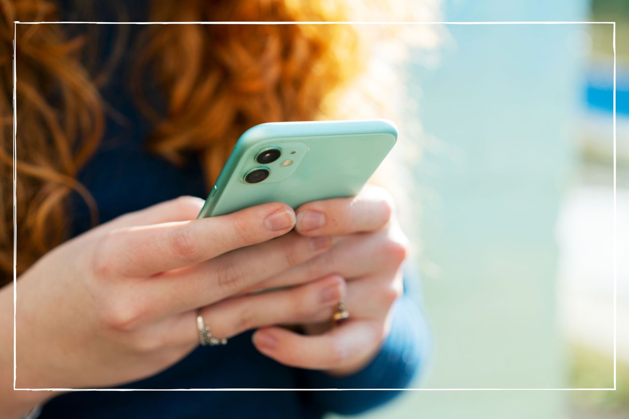 close up of woman&#039;s hands holding a smartphone in a turquoise case