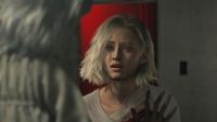 A close-up of Grace talking with someone through glass in Resident Evil Requiem