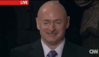 Former NASA astronaut Mark Kelly watches as his wife, Arizona Congresswoman Gabrielle Giffords, receives a warm welcome by President Barack Obama at the State of the Union speech in Washington on Jan. 24, 2012.