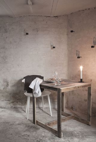 Room with raw wooden table a chair and blanket