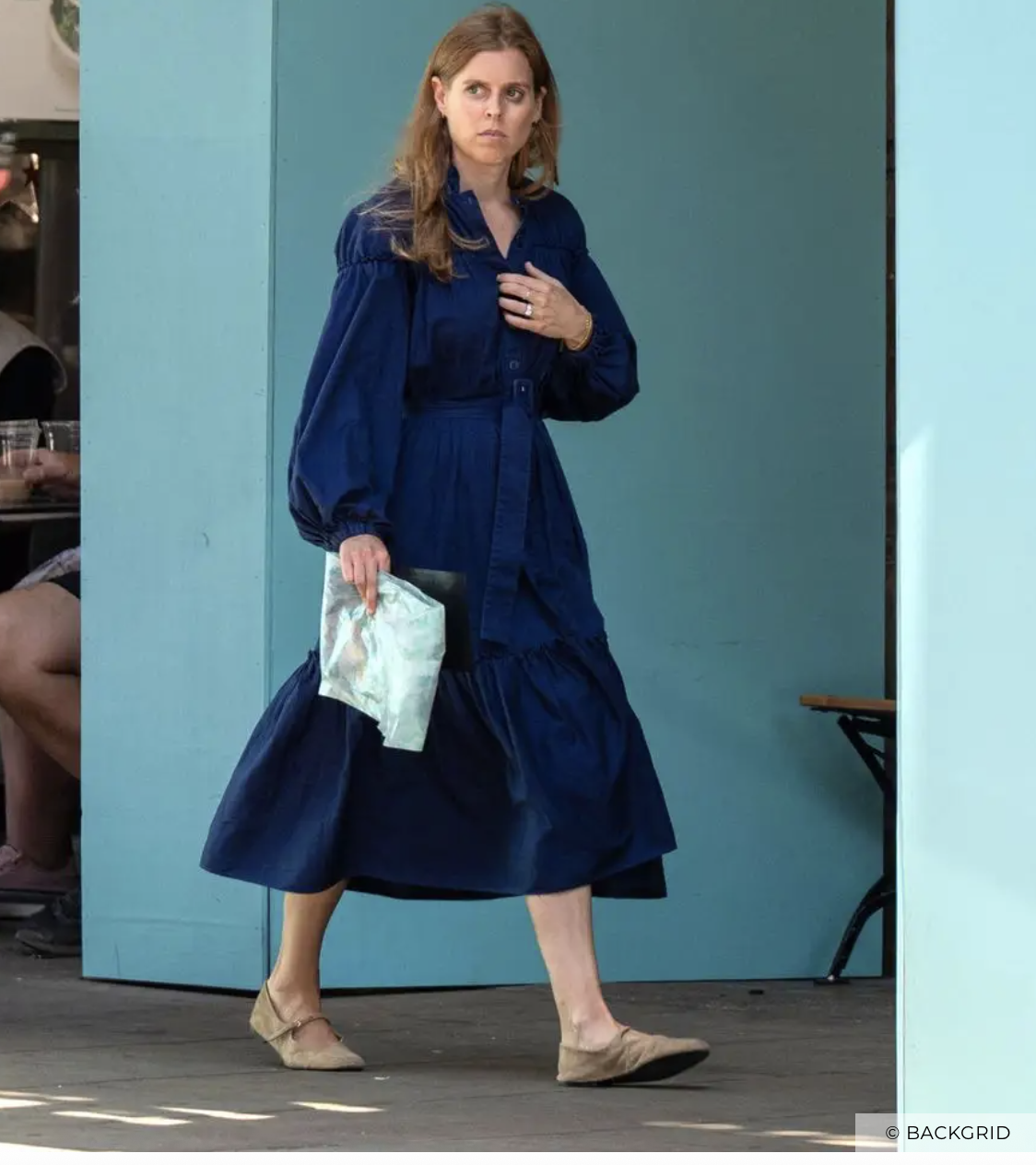 Princess Beatrice wearing a blue dress walking down the street