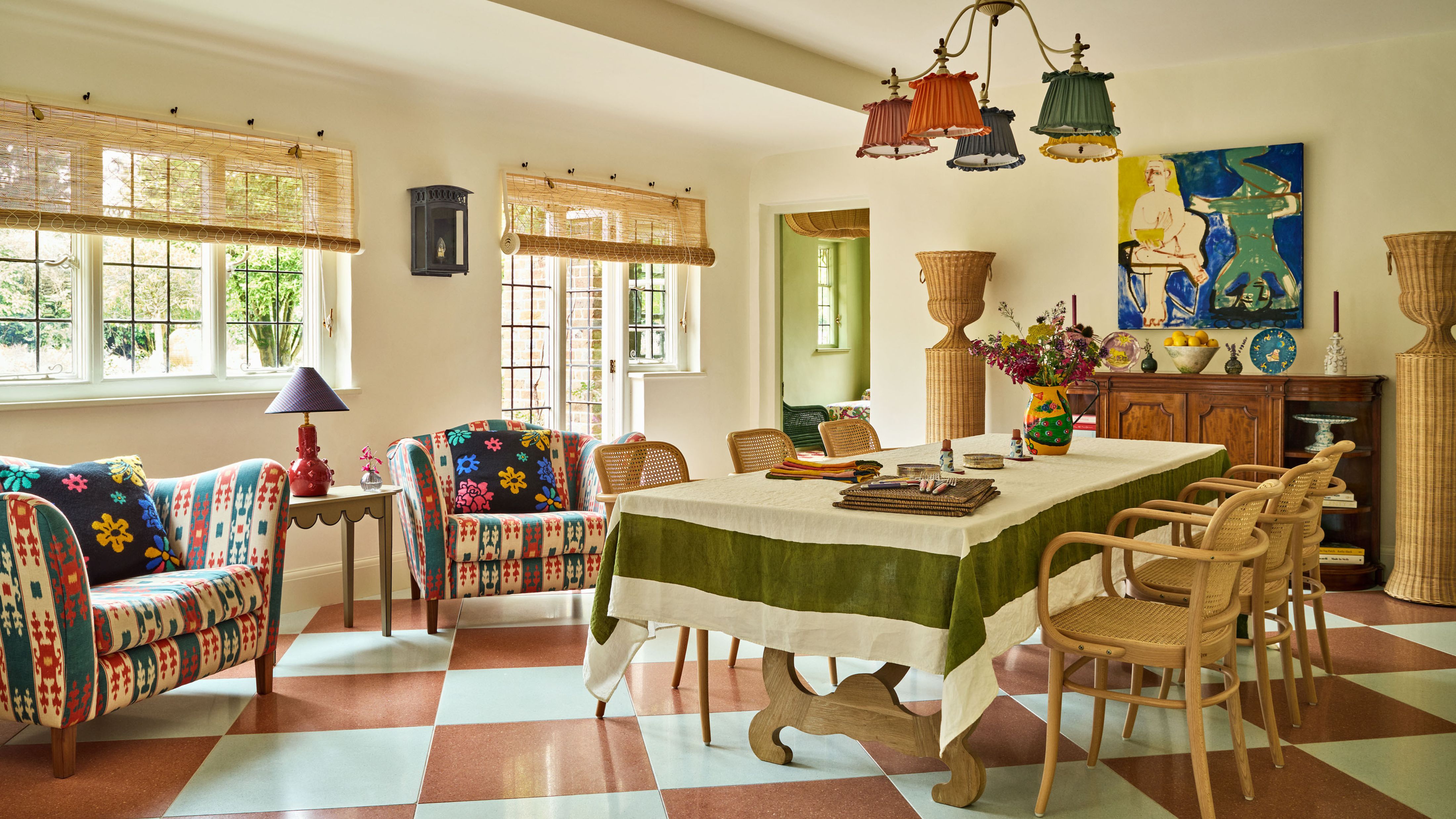 Cheerful ussex dining room with checkered floors, patterned accent chairs, wooden furniture, and colorful accents by Studio Hollond