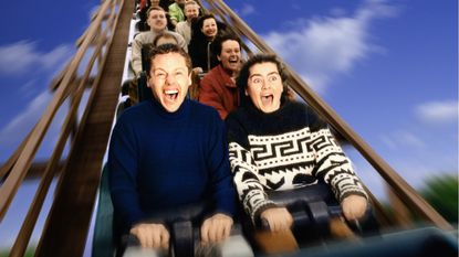 Two young men on a roller coaster. One looks terrified, and the other is having a great time.