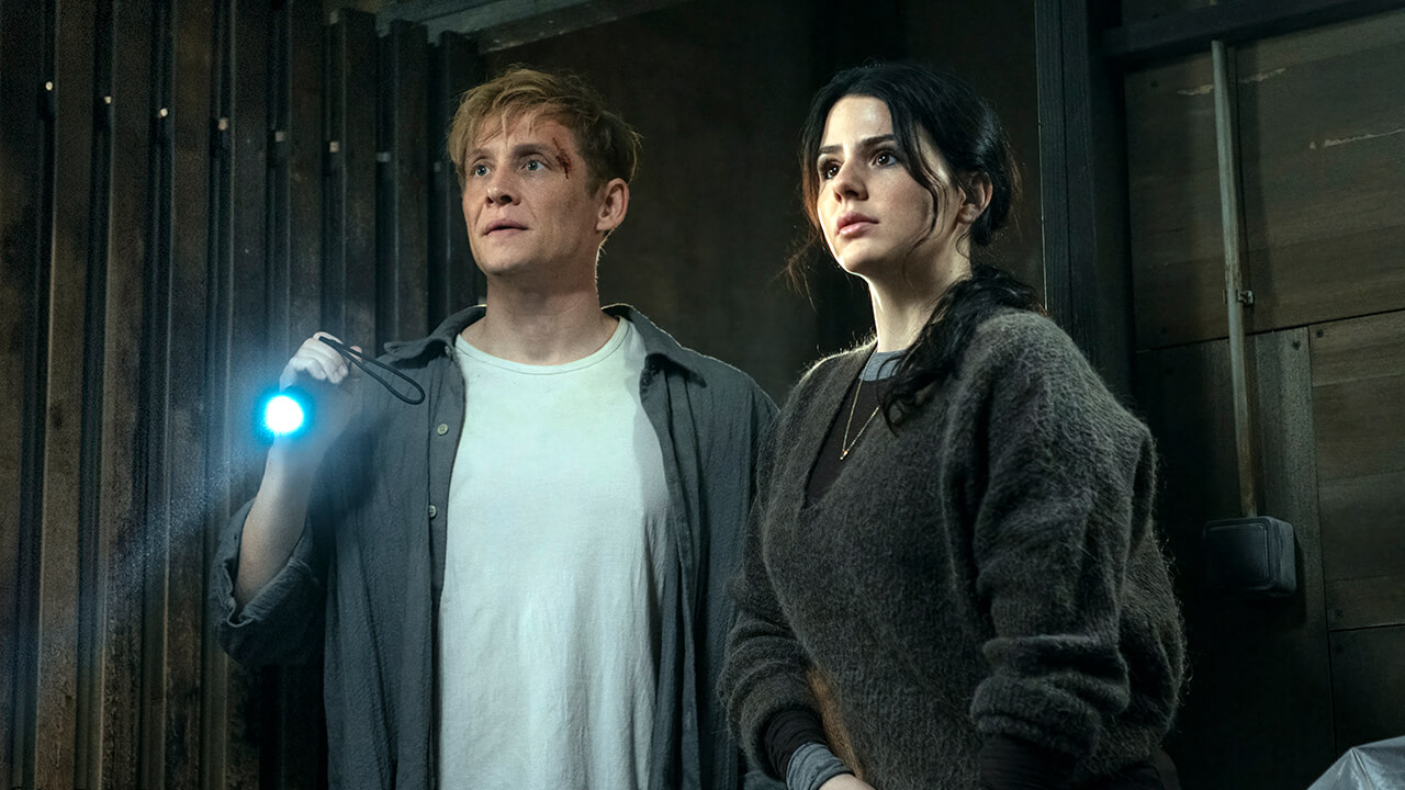 Tim holding a flashlight and standing next to Olivia in Brick