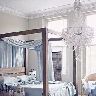 bedroom with wooden cot and bed with white ceiling light