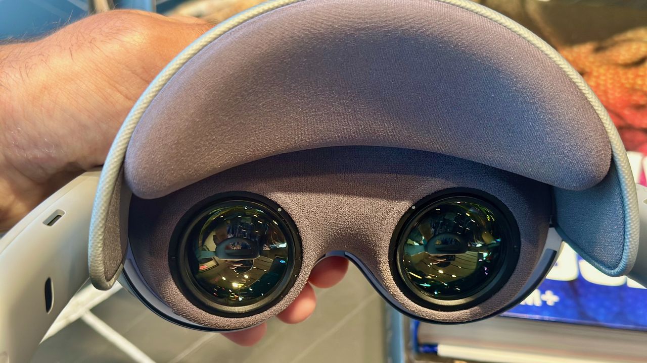 A close-up photo of the Samsung Galaxy XR headset held in hand, pointed toward the lenses.