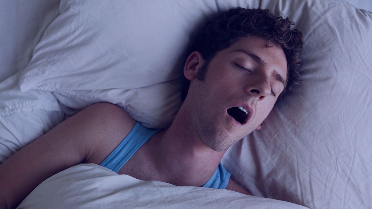 A person asleep in bed, snoring