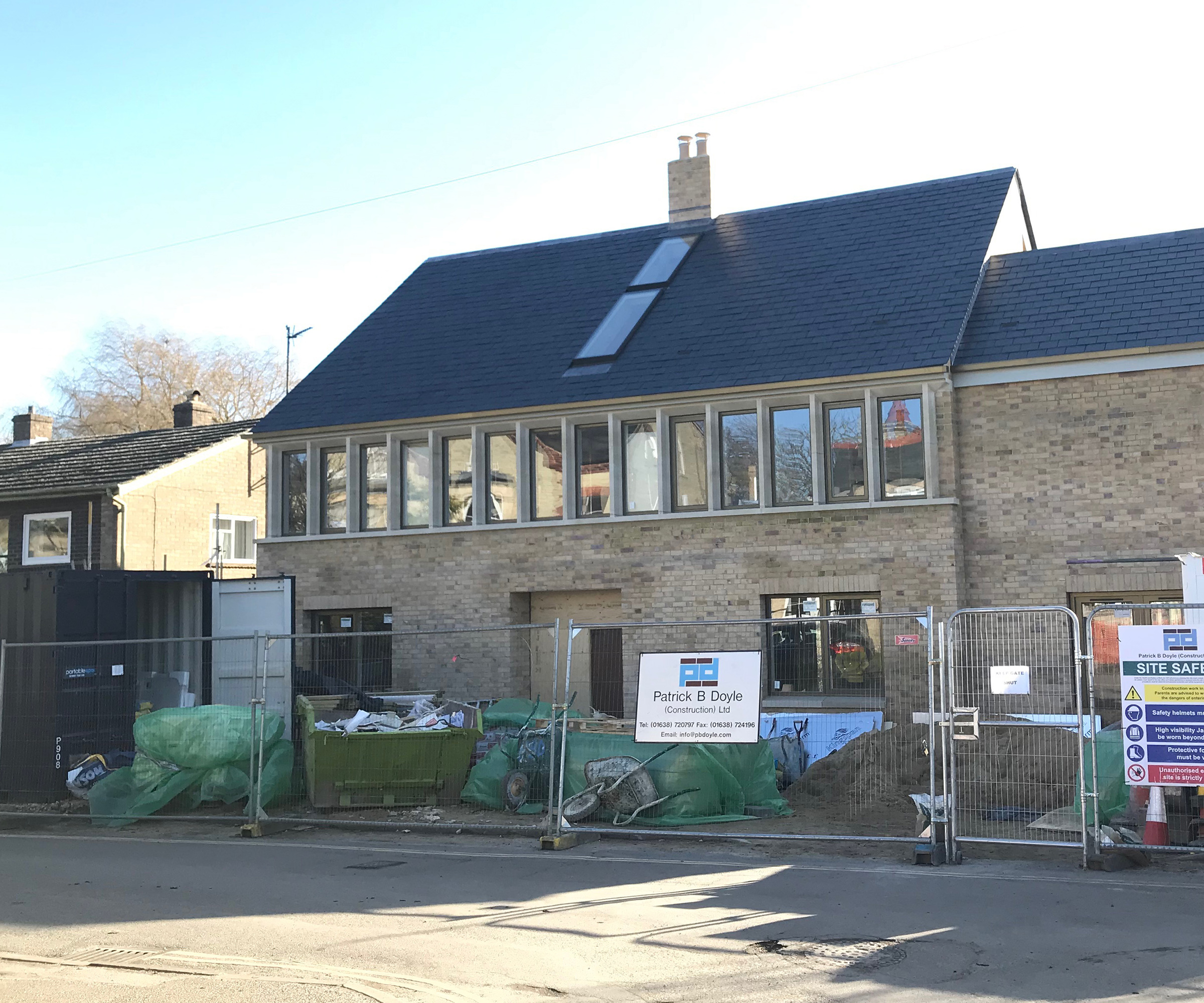 A self build house under construction with metal railings protecting the build site