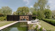 black timber clad garden room with pool