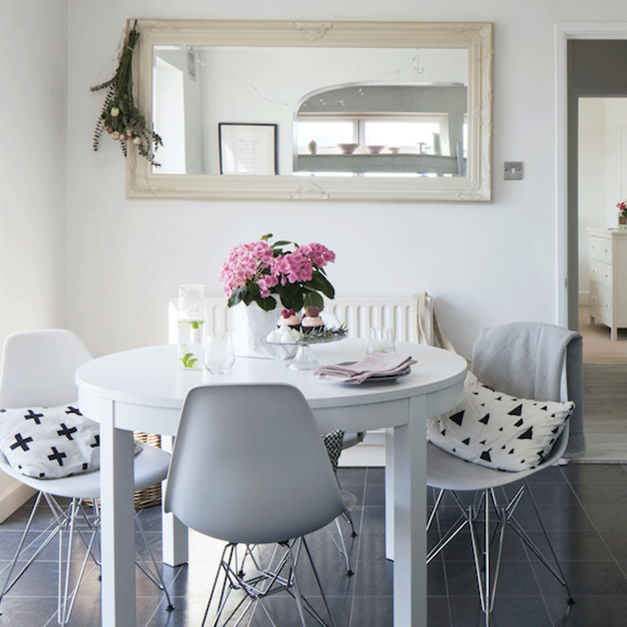 White dining room with wooden table and mirror