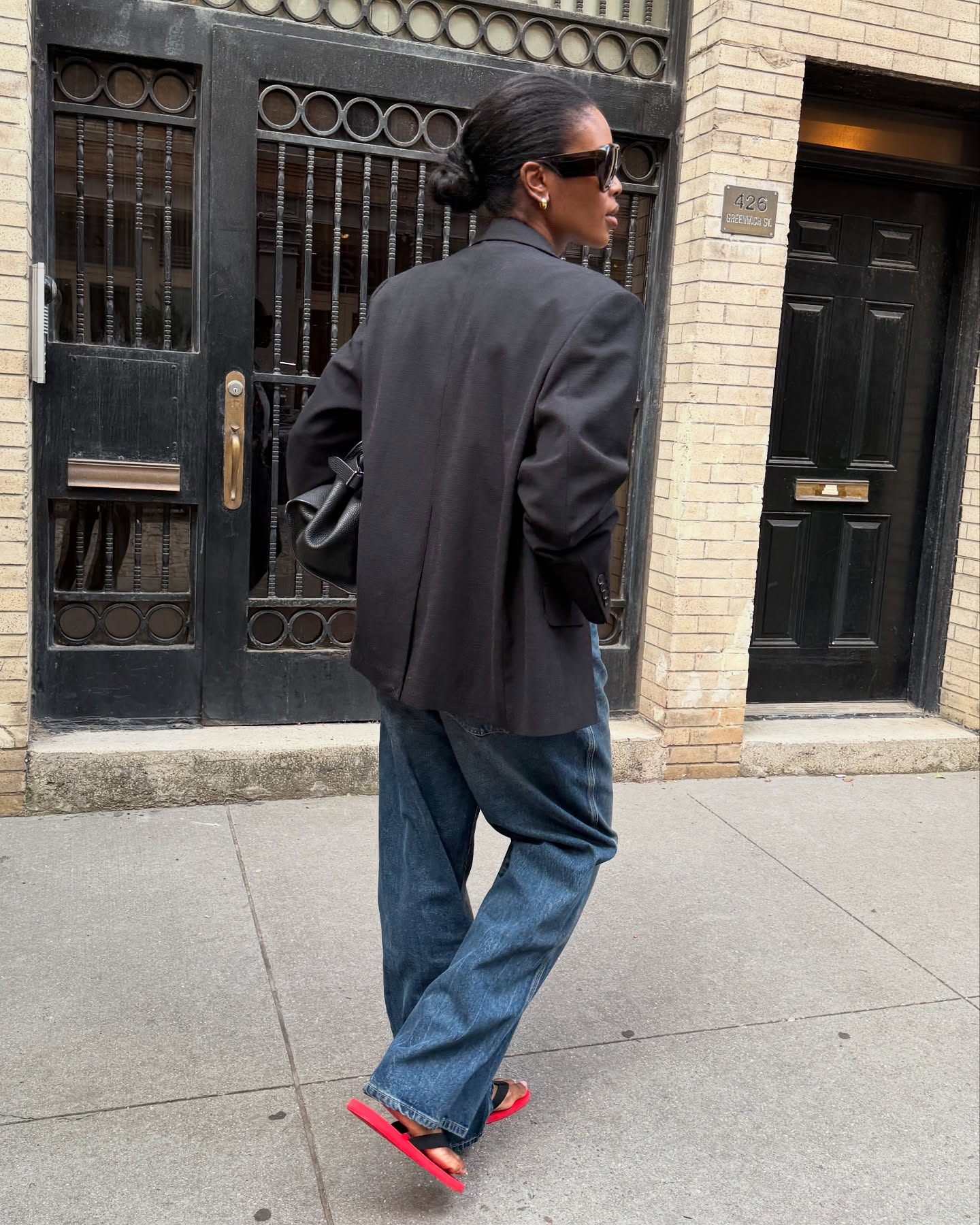 An image of @nlmarilyn wearing red-and-black flip-flops with blue jeans and a black blazer.