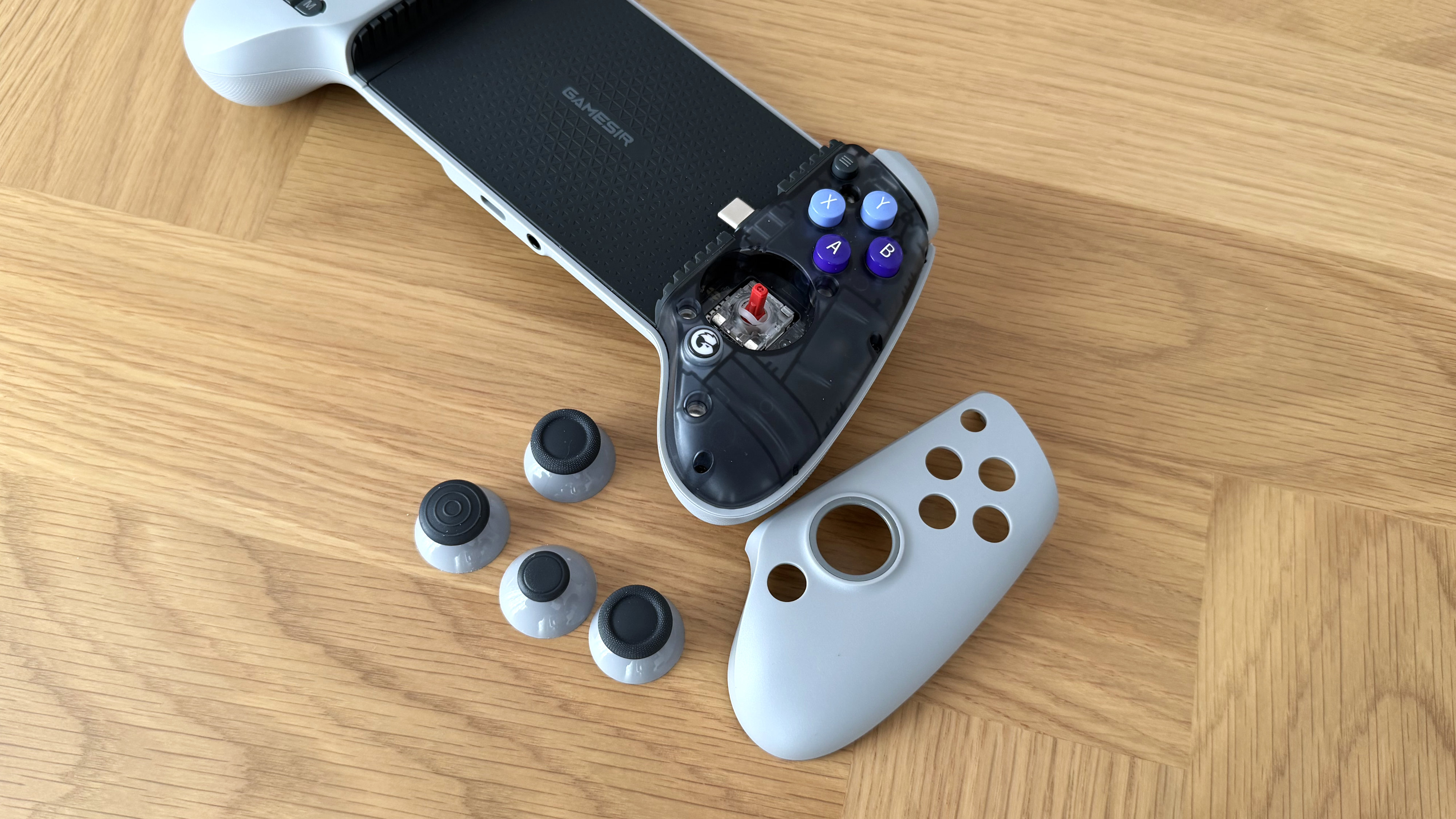 The GameSir G8 Galileo mobile gaming controller on a wooden surface.