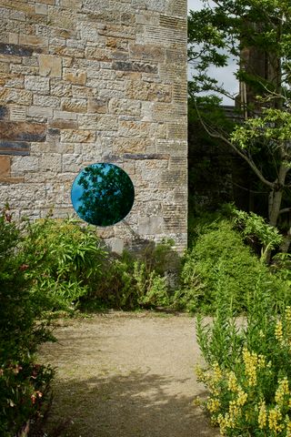 Charlotte Moth, Blue reflecting the greens (2021). Blue mirror disk, metal powder coated frame and pivoting armature. © Charlotte Moth. Photography: Ros Kavanagh