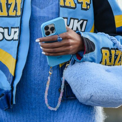 Close up of street style image showing woman with square nails holding her phone