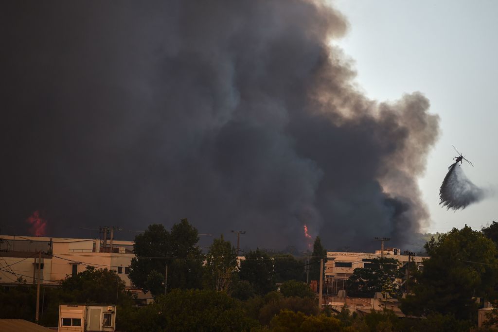 A water-dropping helicopter over a fire in Athens.