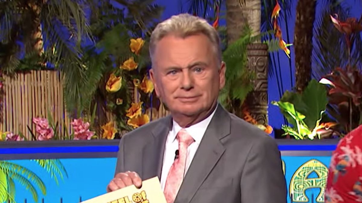 Pat Sajak holding prize envelope on Wheel of Fortune