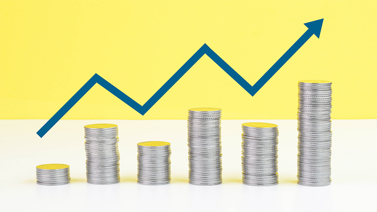 Piles of silver coins in front of yellow background, with cartoon rising trend line