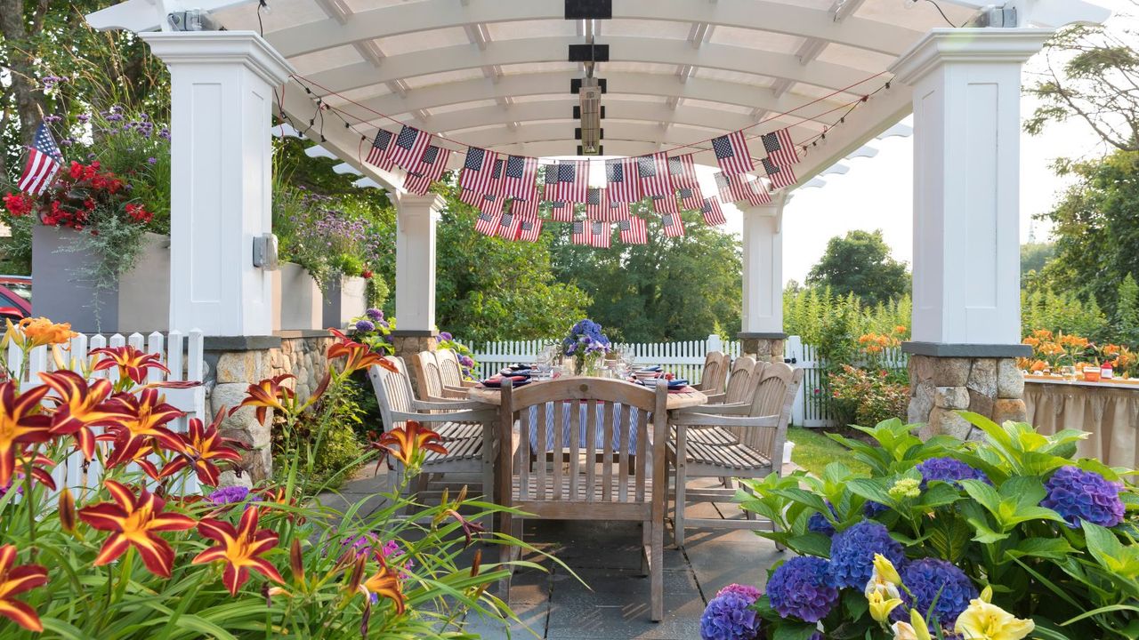 Festive Fourth of July party table set under garden pergola in Chatham, Massachusetts, United States