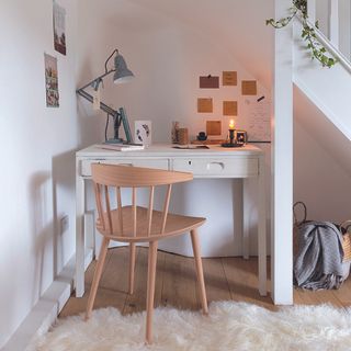 Under stairs home office with white desk and wooden chair