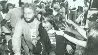 Danny Francis ushering Bon Jovi's Richie Sambora through a crowd
